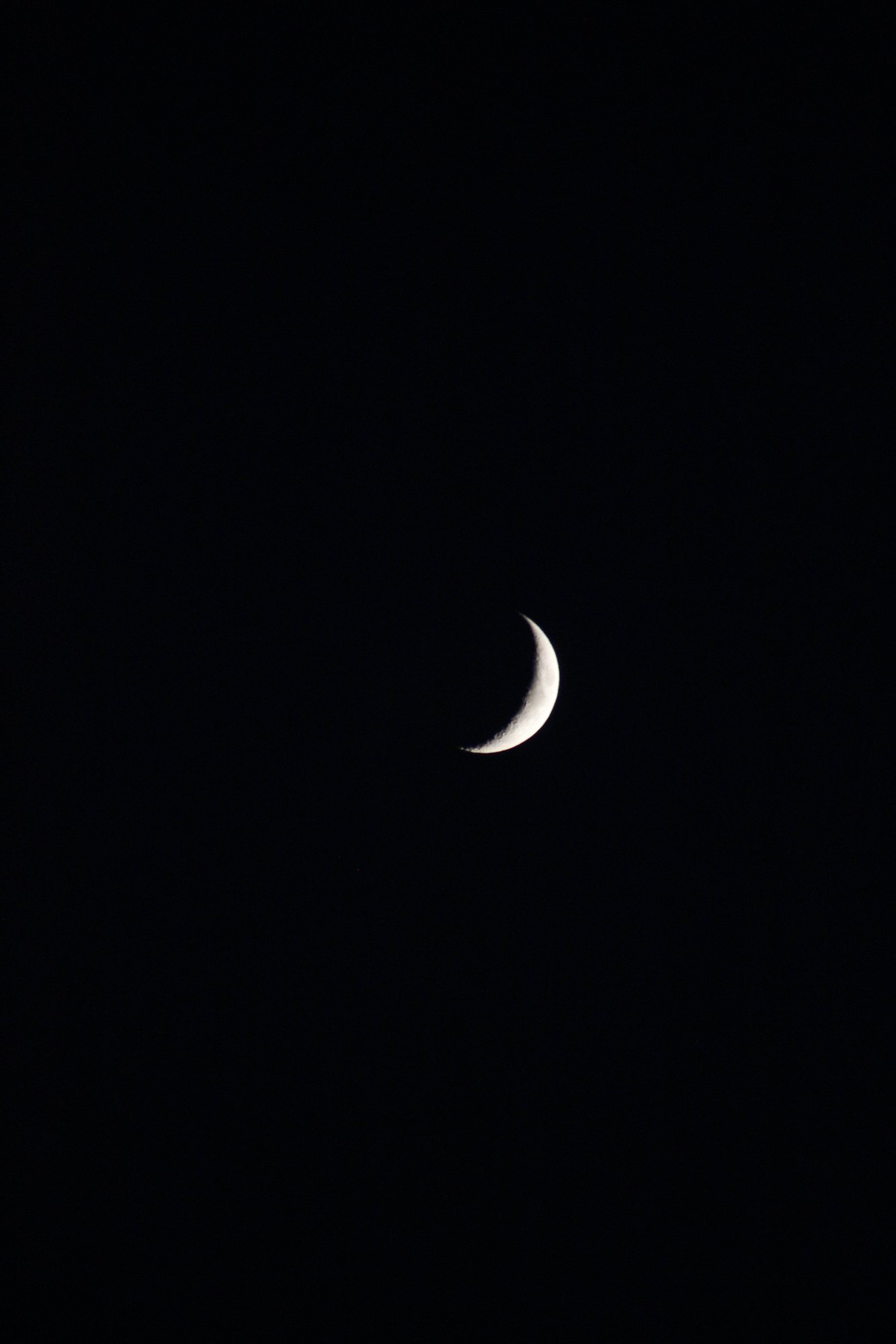 A crescent moon in a black sky