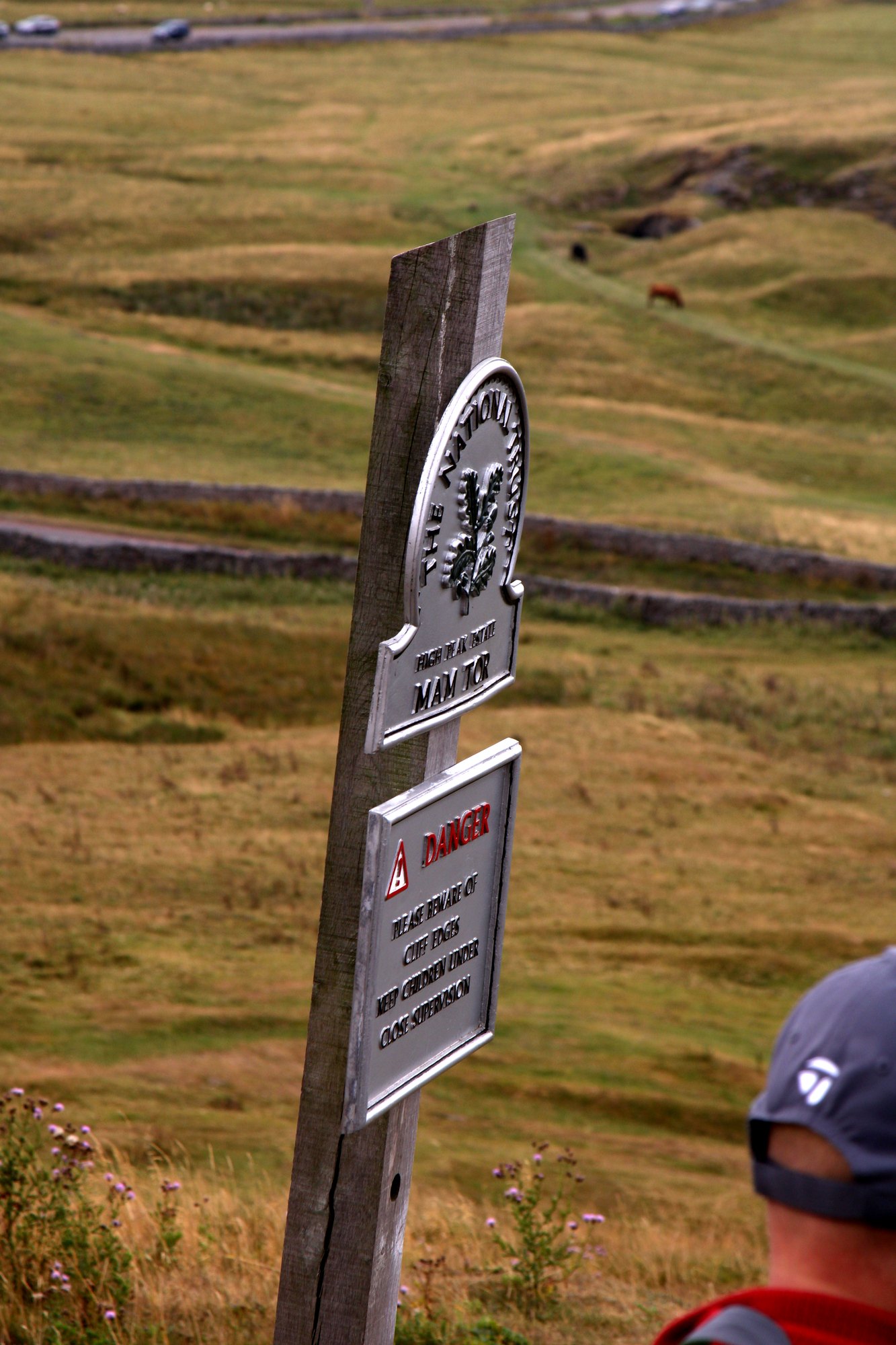 A National Trust sign on a wooden post above the valley