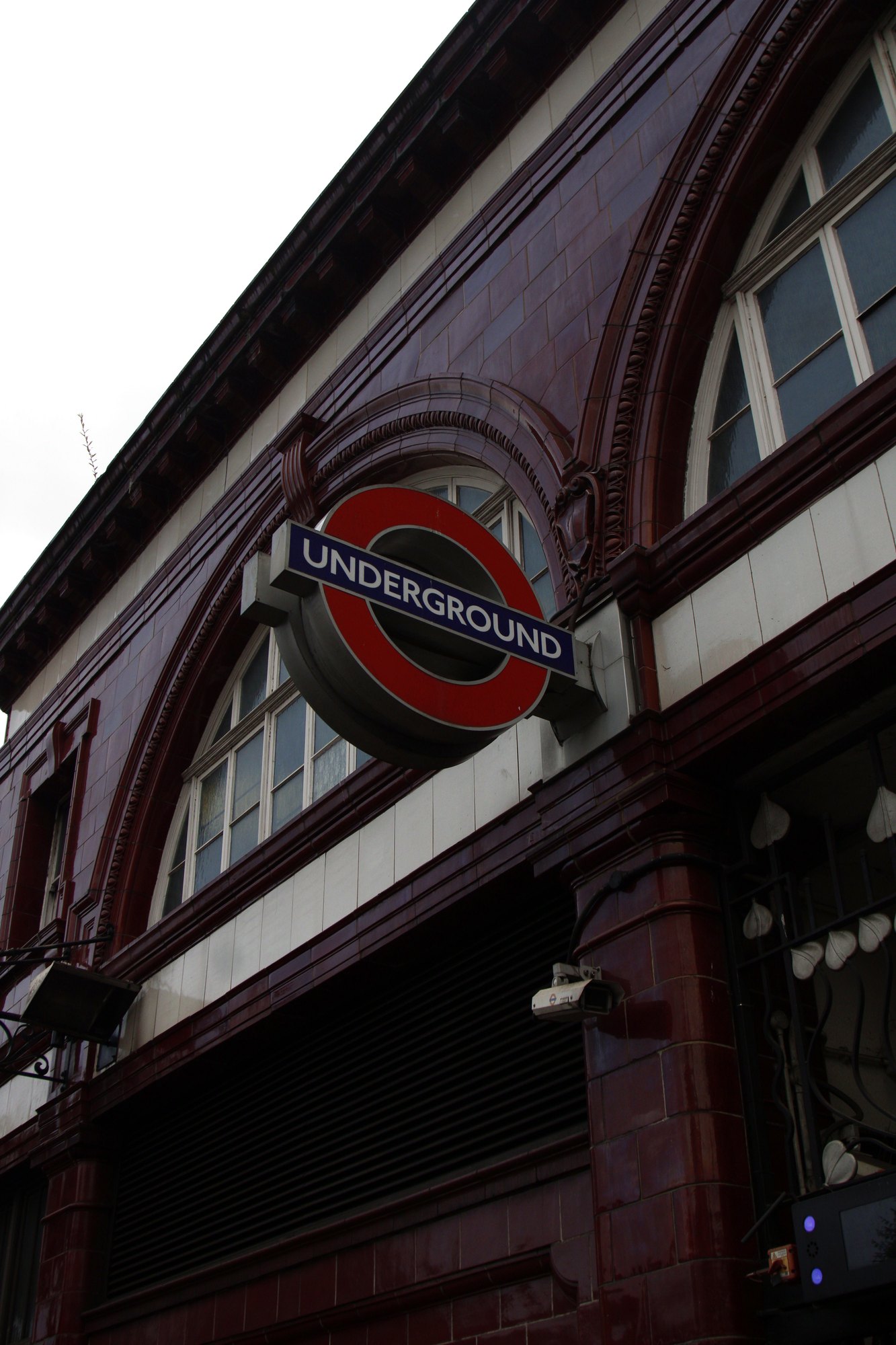 London Underground roundel on a red-tiled station front